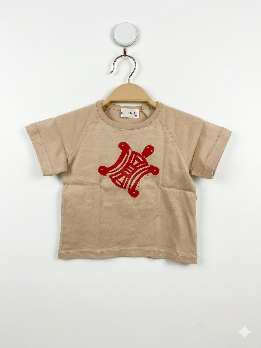 Front view of an authentic Celine baby tan t-shirt featuring a red turtle graphic, hanging on a wooden-style hanger against a Tiny Thrift Store branded background.