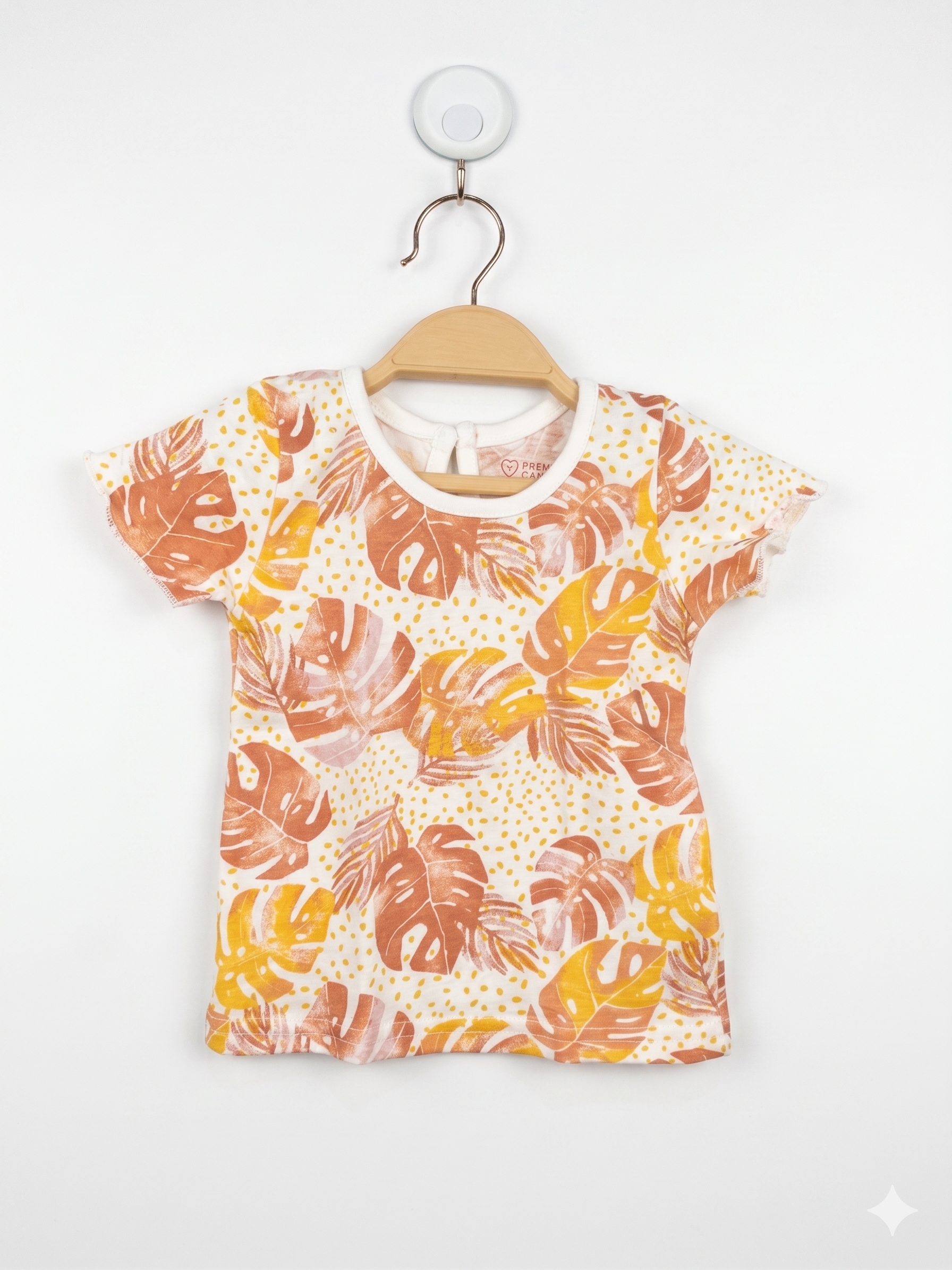 Front view of Primark Cares baby girl t-shirt with orange and yellow tropical leaf print and ruffle sleeves.
