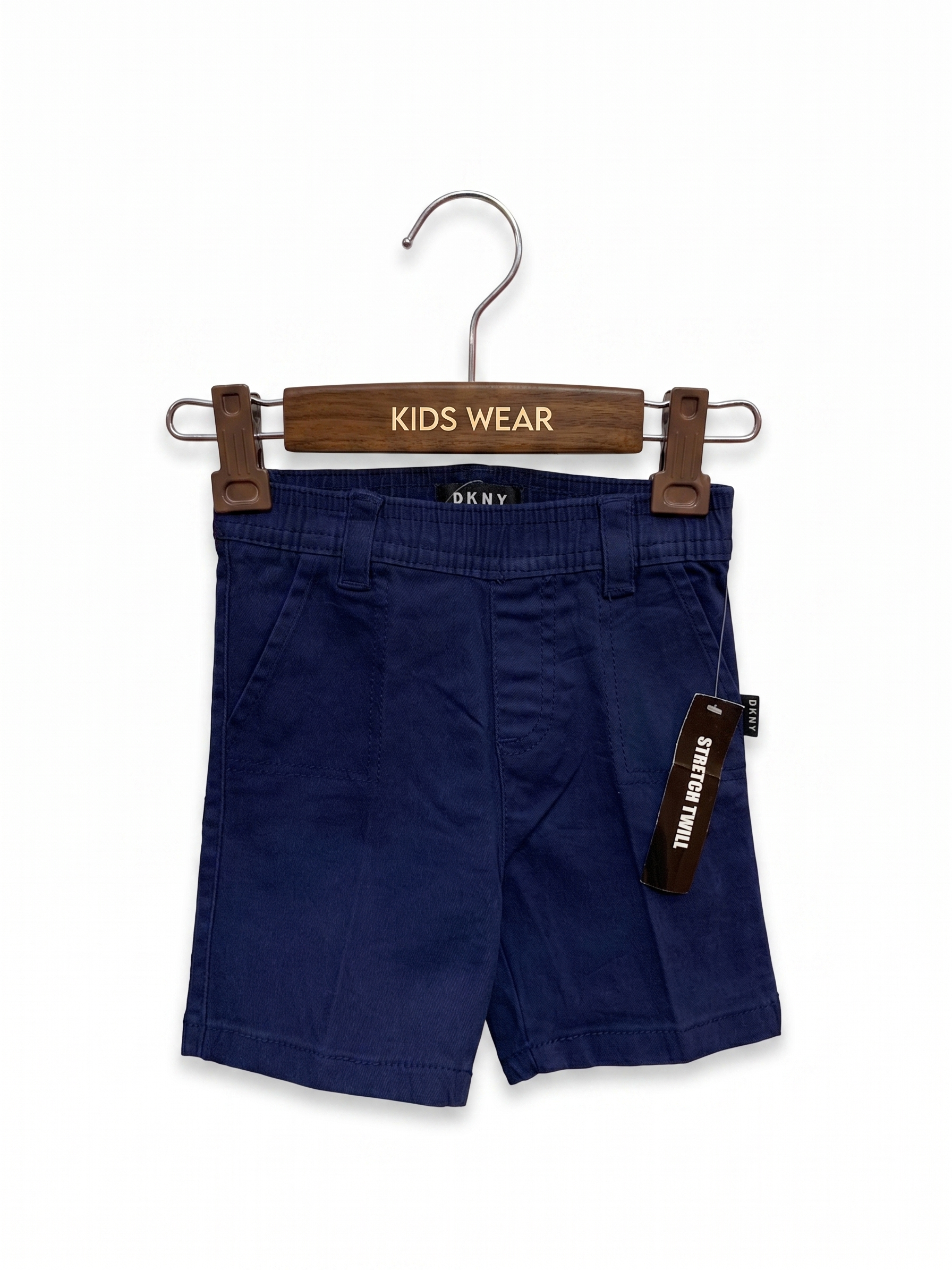 DKNY baby boys' navy blue stretch twill shorts featuring an elastic waistband and side pockets on a hanger.