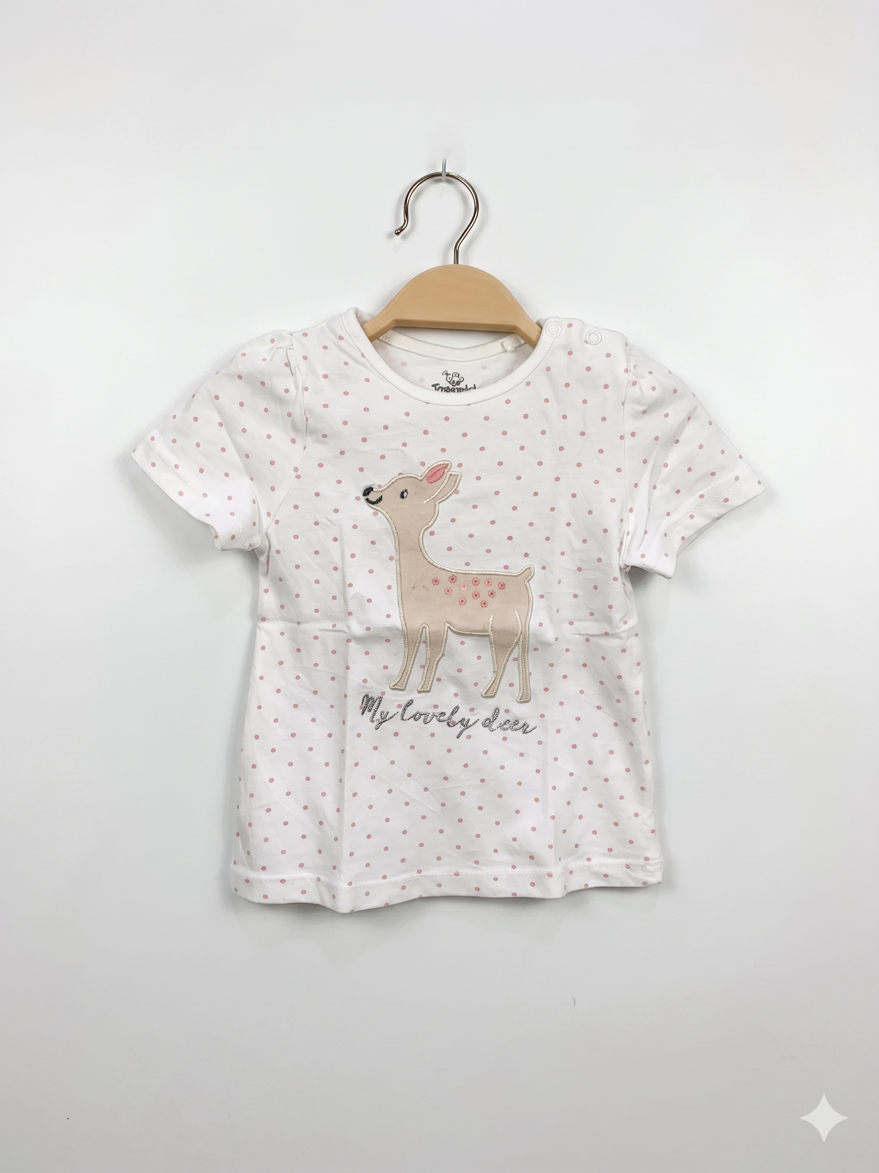 Front view of Topomini baby girls white t-shirt with pink polka dots and embroidered deer graphic on a hanger.