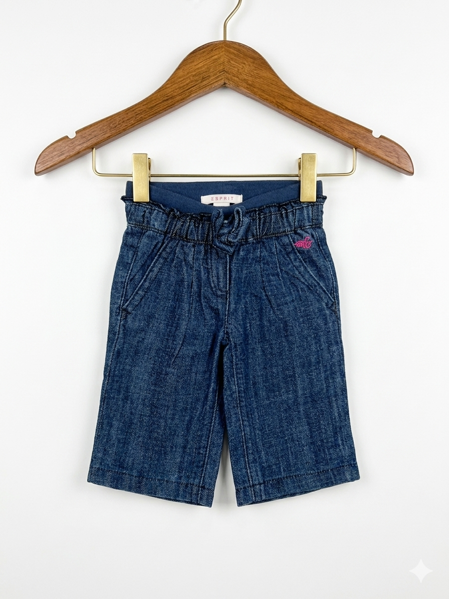 Front and back view of Esprit baby girl denim shorts for 1 month old, featuring a ruffled elastic waist and pink heart embroidery on the back pockets, displayed on a pink hanger.