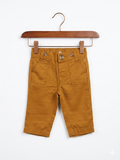 Newborn Cat and Jack mustard yellow chino trousers for baby boys with elastic waistband and button details on a white hanger against a Tiny Thrift Store backdrop.