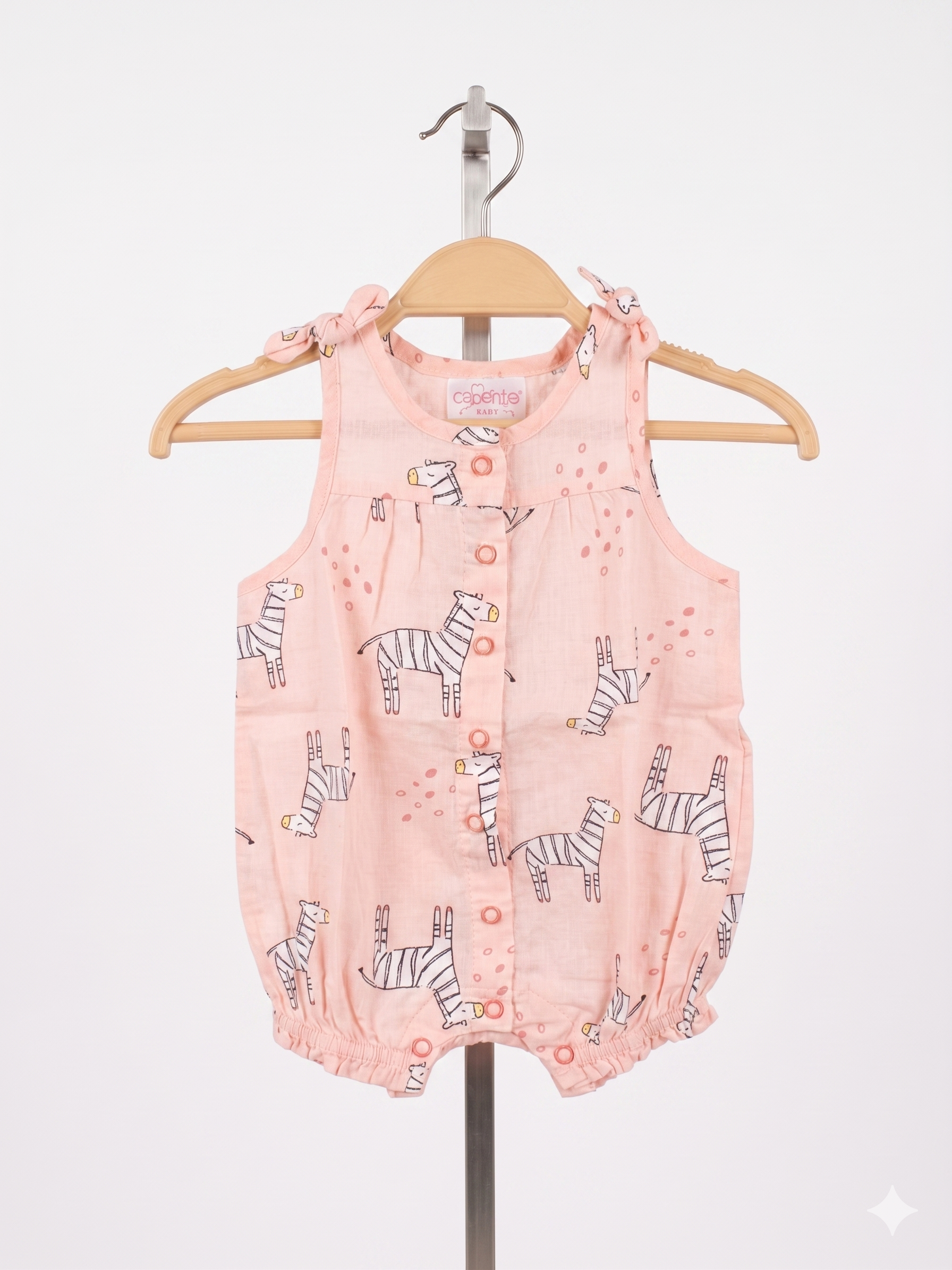 A peach-colored sleeveless baby romper with a white zebra pattern, featuring front buttons and tie-up shoulders, displayed on a hanger against a Tiny Thrift Store background.