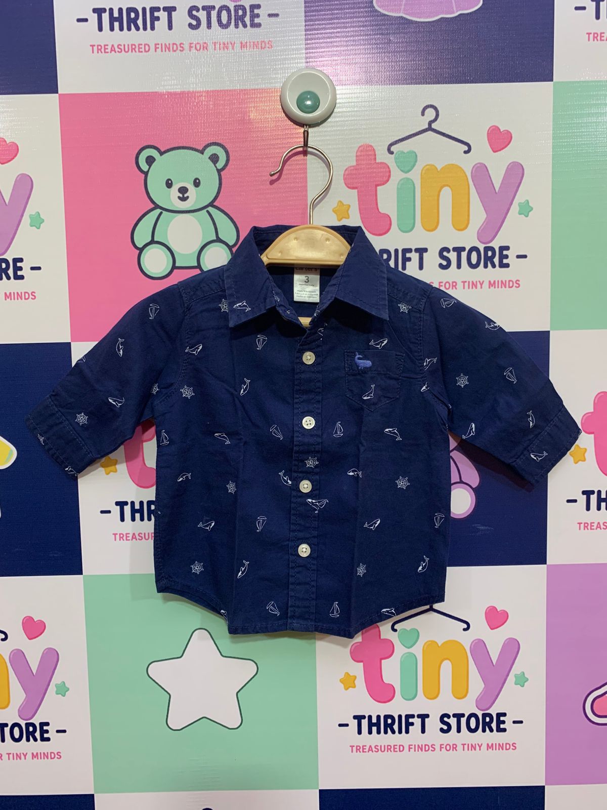Front and back view of a navy blue long-sleeve infant shirt by Carter's. The shirt has white prints of whales and anchors. Close-up shows the "Carter's 3 months" tag.