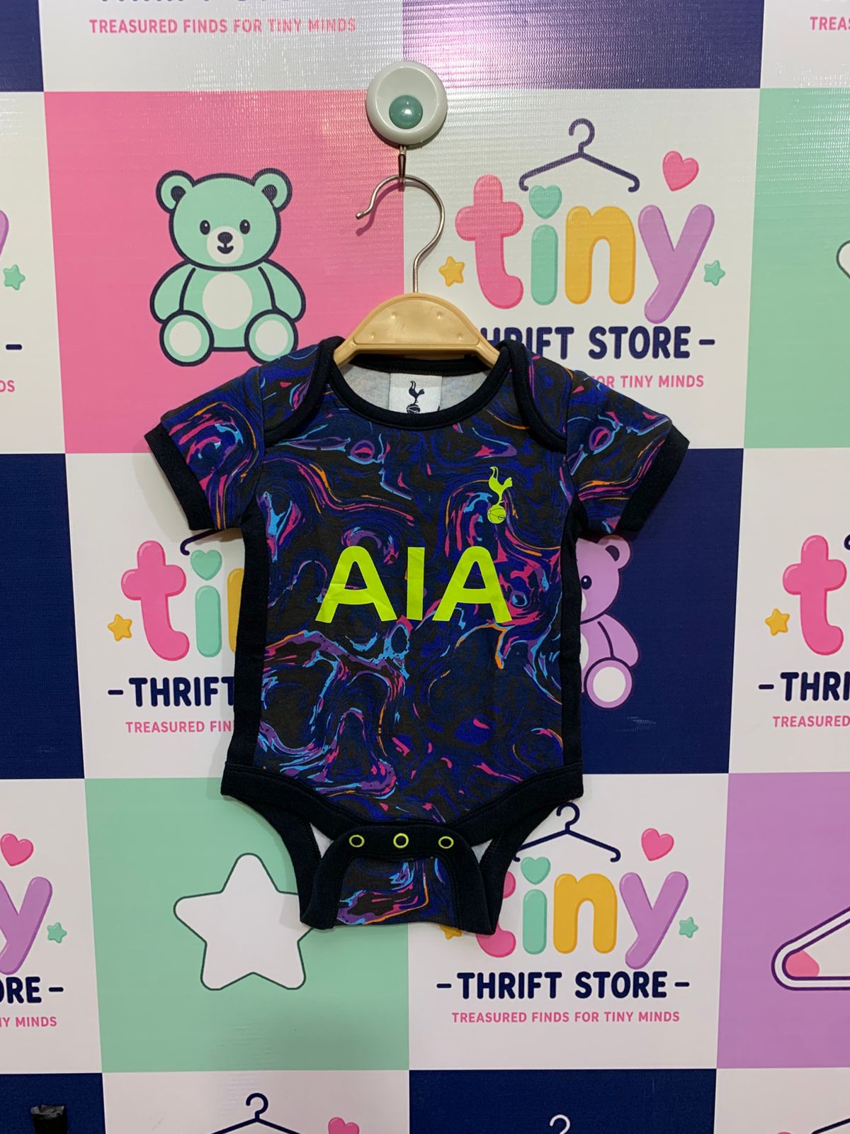 Carter's Front: A baby boy's peach and grey checkered long-sleeve bodysuit on a hanger.