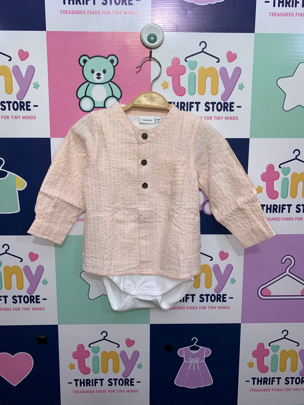 "Baby boy long-sleeve shirt bodysuit in peach and white seersucker stripes. Features a collar, front buttons, and a small pocket. Perfect for smart-casual infant wear."