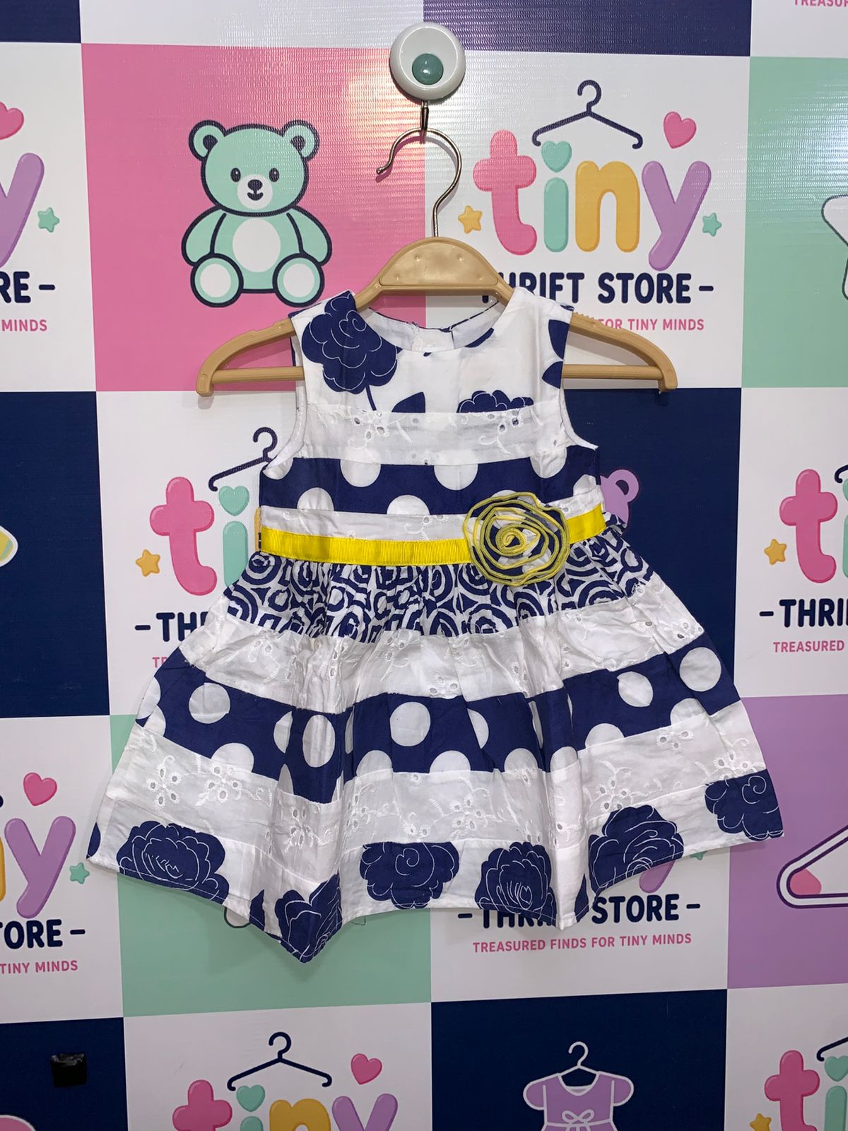 Youngland Baby girl dress in navy and white with floral patterns, polka dots, and a yellow rose waist accent.