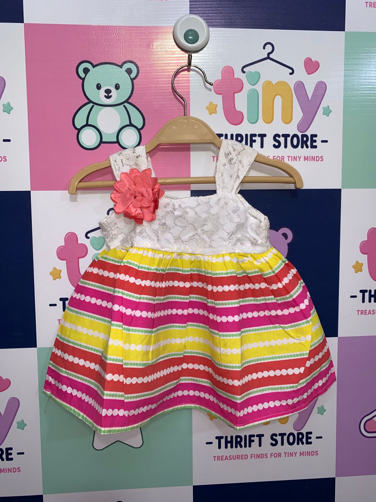 Real Love baby girls dress featuring white lace bodice with a pink flower and vibrant striped skirt.